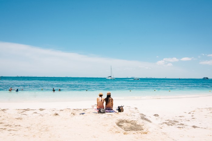 A couple seated in a beach of The Caribbean