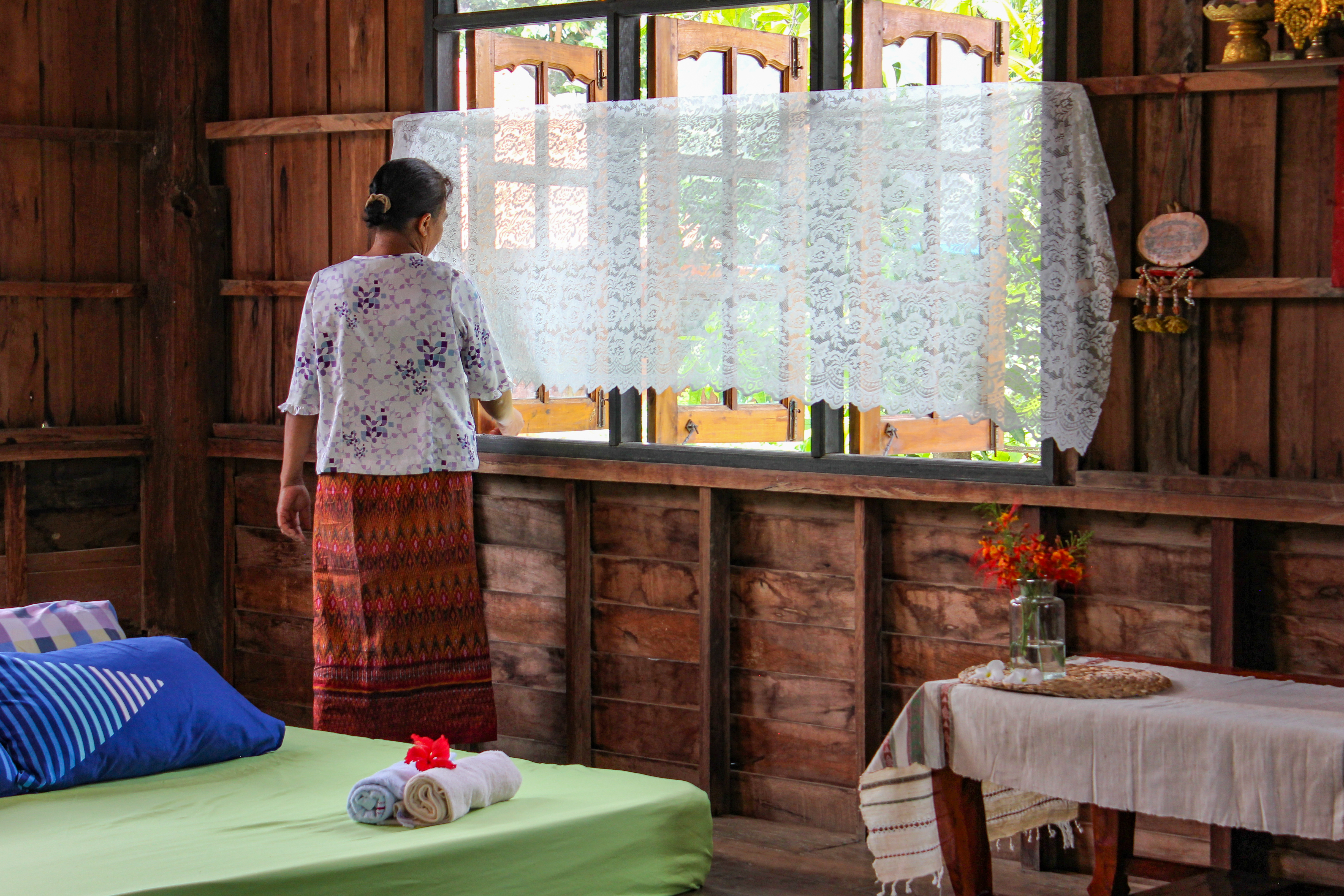 A host cleans and prepares her bedroom for her next Airbnb guest in Buriram, Thailand.