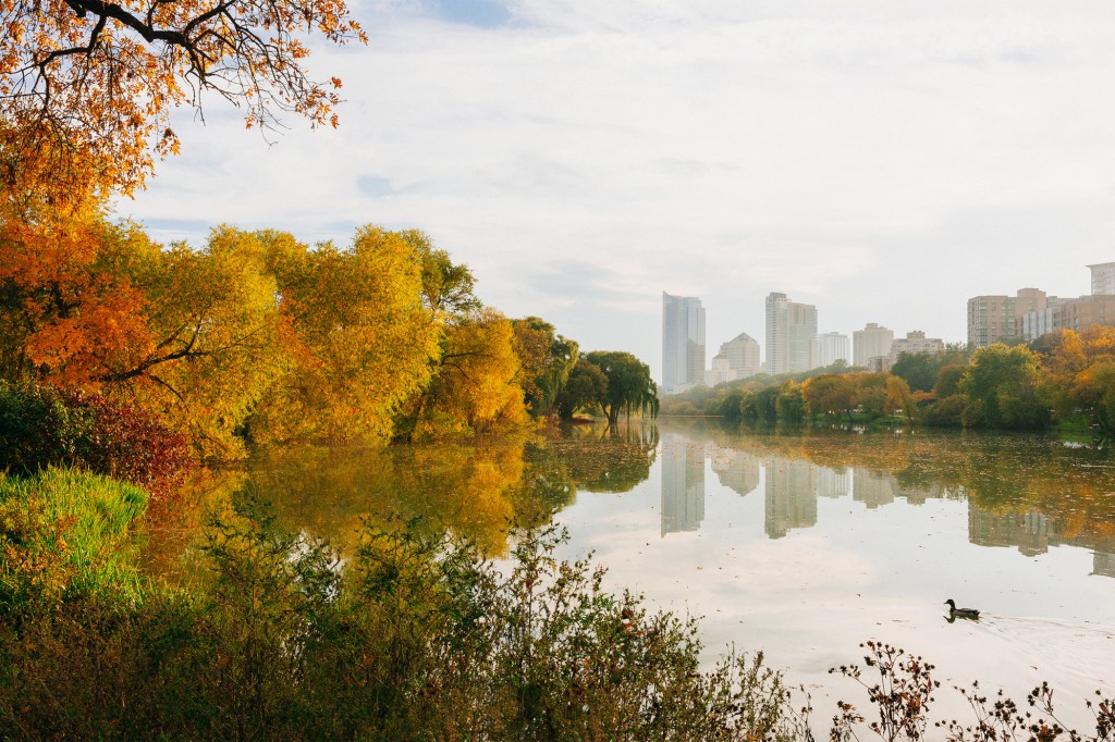 Scenic view of a lake by Milwaukee buildings against sky during autumn.