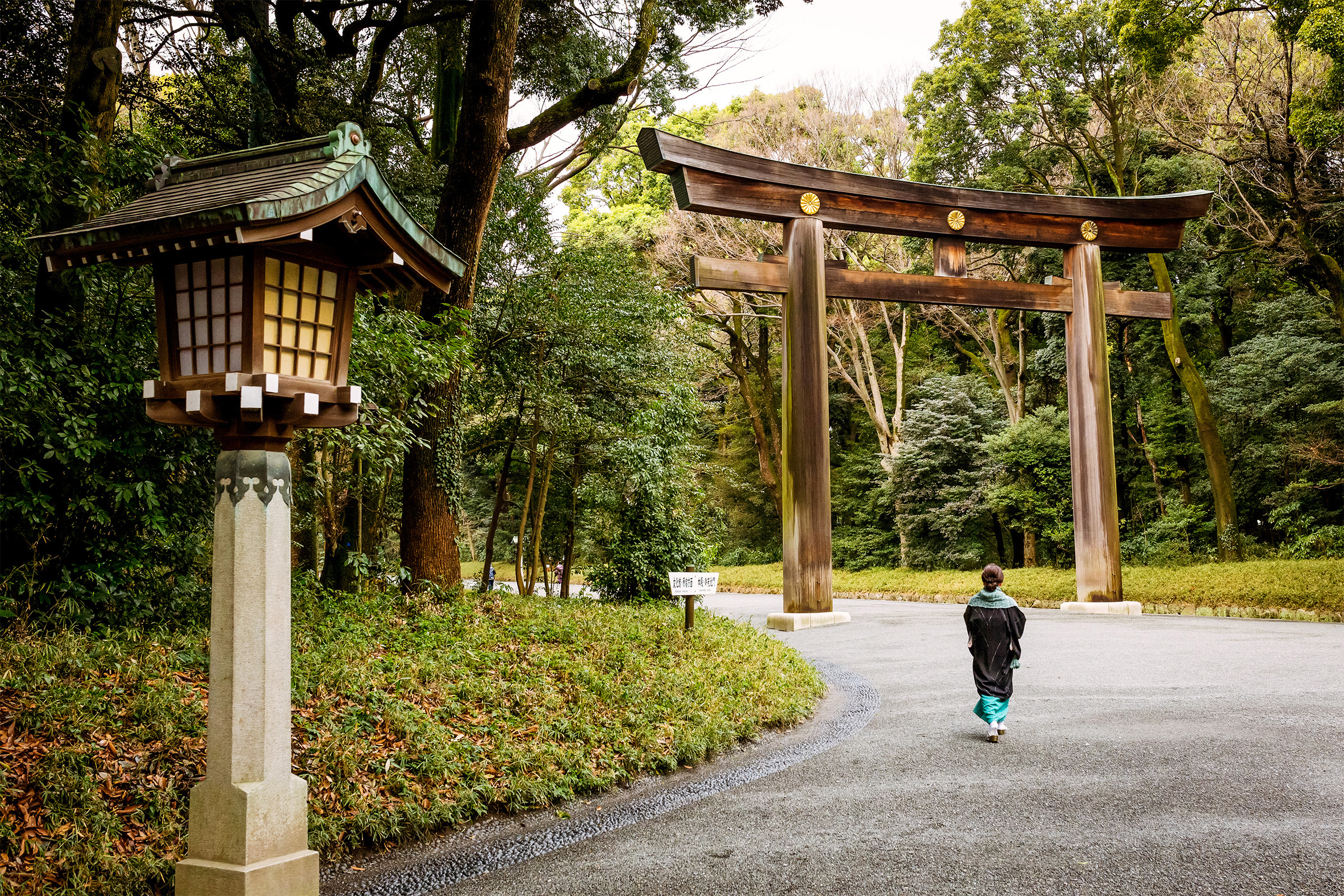 A woman walks alone down a serene road in Tokyo, Japan.