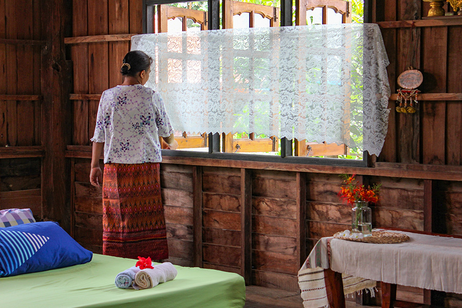 A host cleans and prepares her bedroom for her next Airbnb guest in Buriram, Thailand.