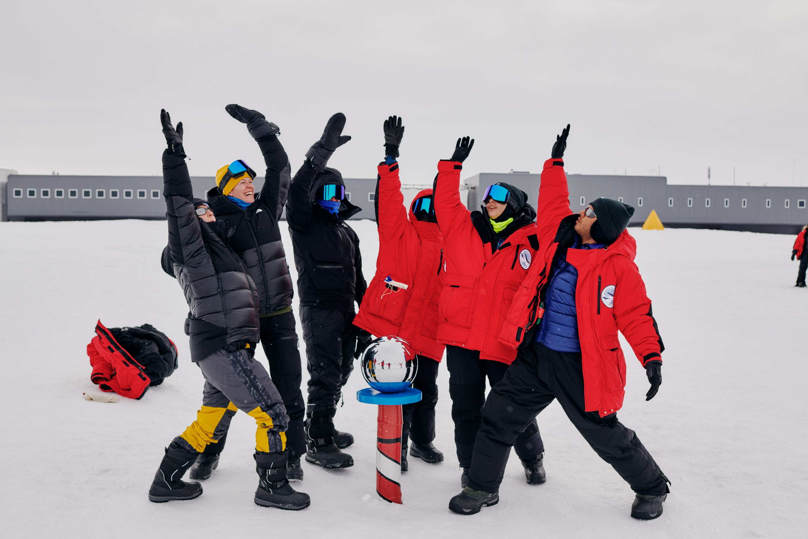 Antarctic Sabbatical volunteers celebrating at the Ceremonial South Pole
