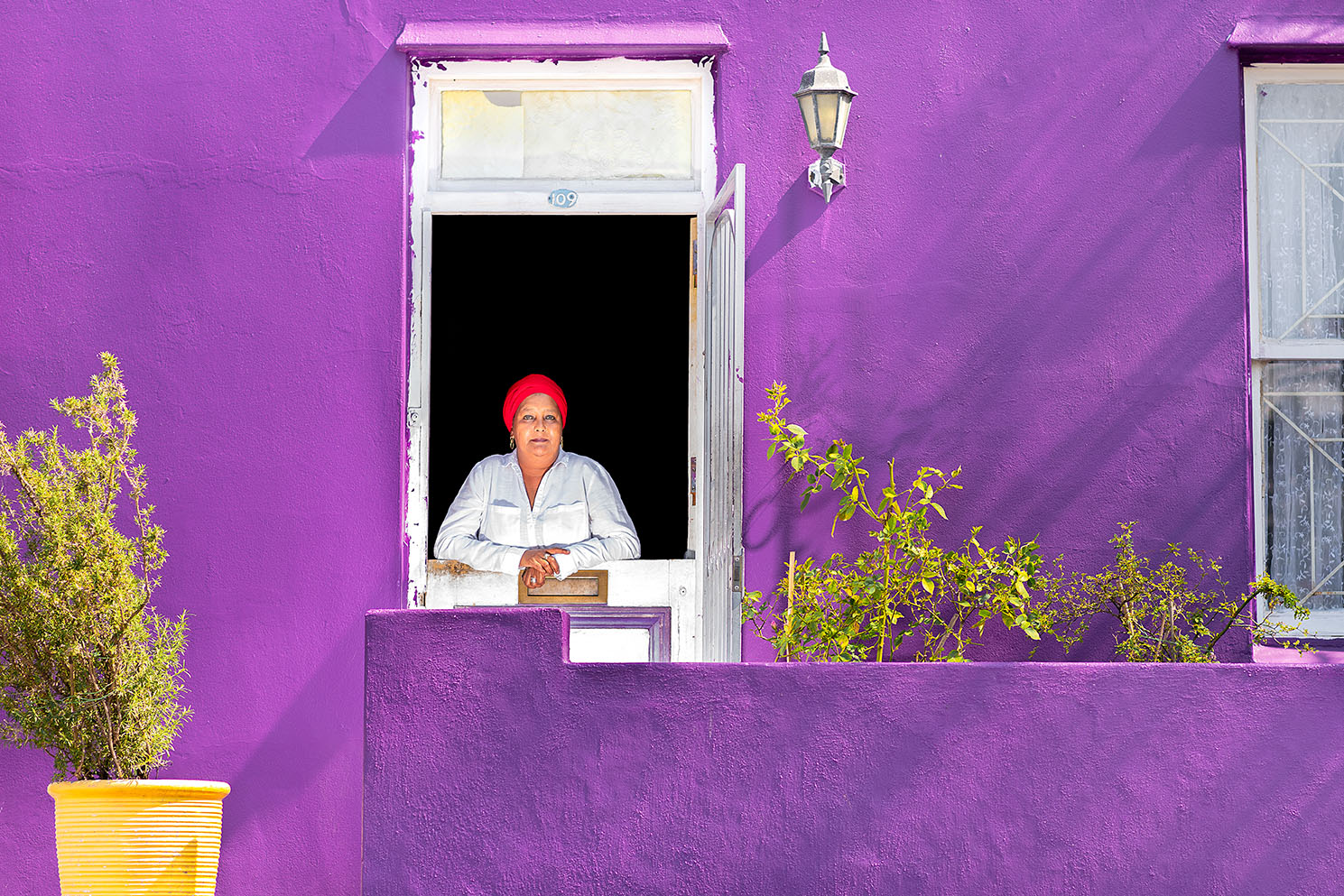 A woman standing in the doorway of a purple home