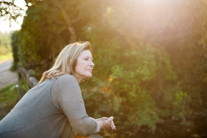 An Airbnb host looks out onto her yard during sunset.