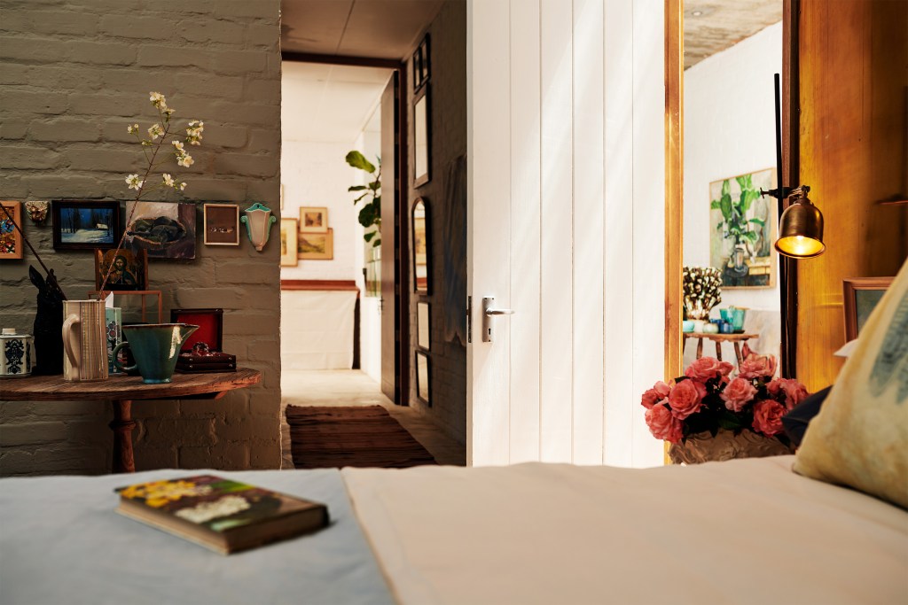 Fresh pink roses pop in a clean Airbnb listing bedroom ready for its next guest.