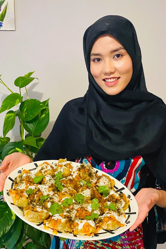 Masomah Alizada holding a plate of traditional Afghan food.