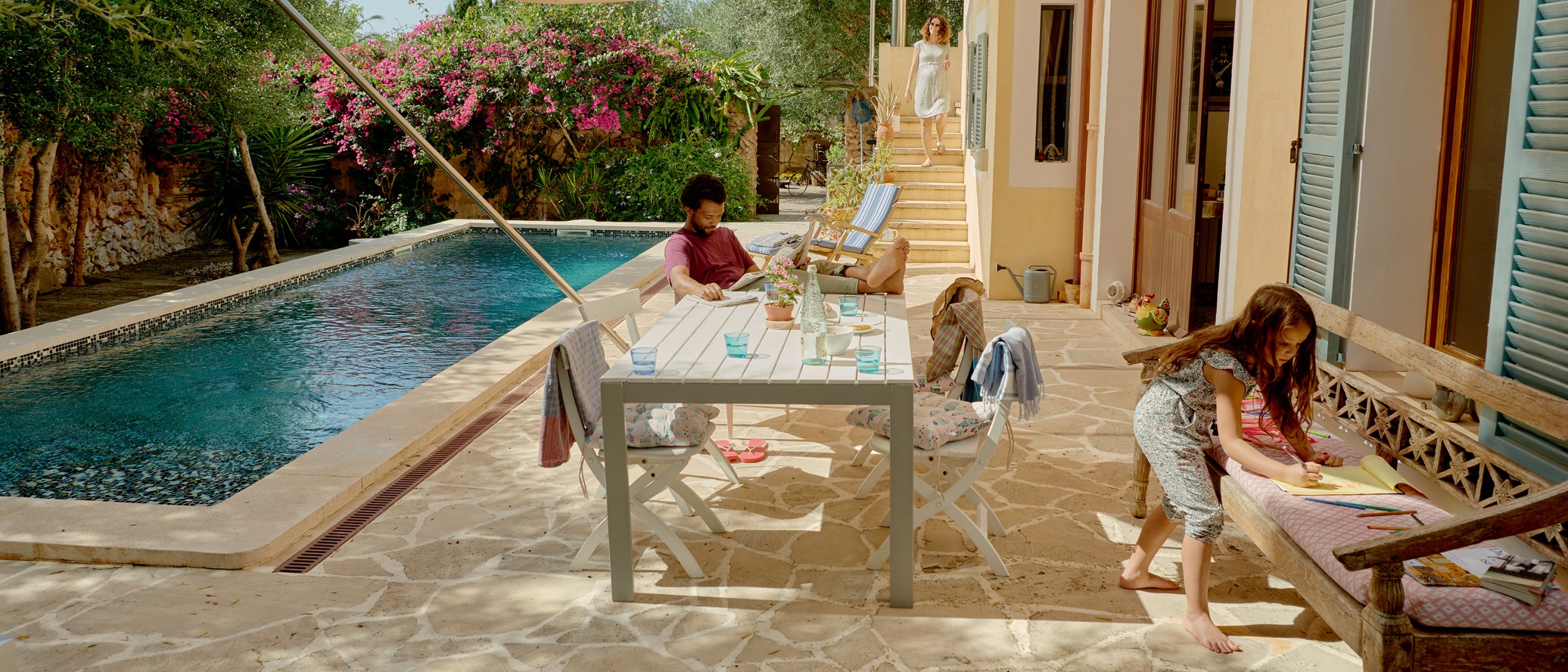 A young family relaxes poolside at an Airbnb listing within driving distance of their hometown.