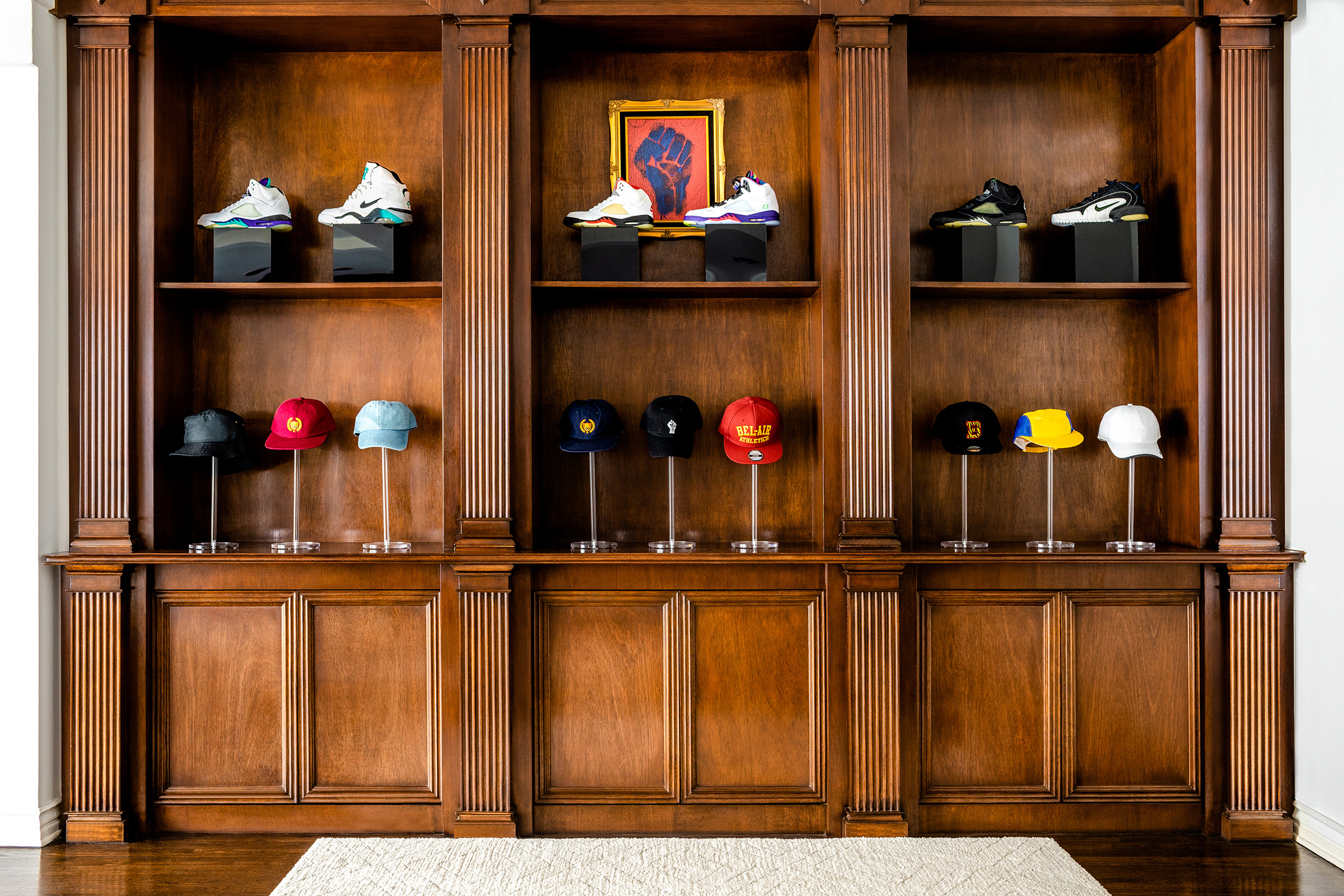 Special Nike sneakers and retro hats line a wall covered in warm wood paneling.