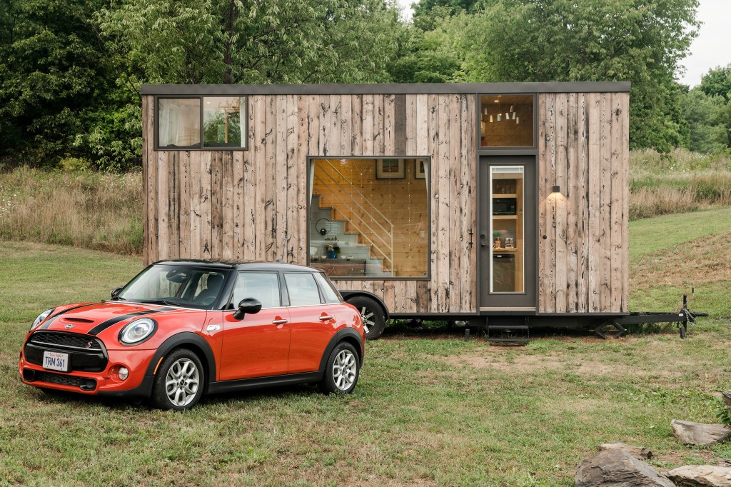A red MINI Cooper is parked outside of an Airbnb tiny home listing in Marlboro, New York.