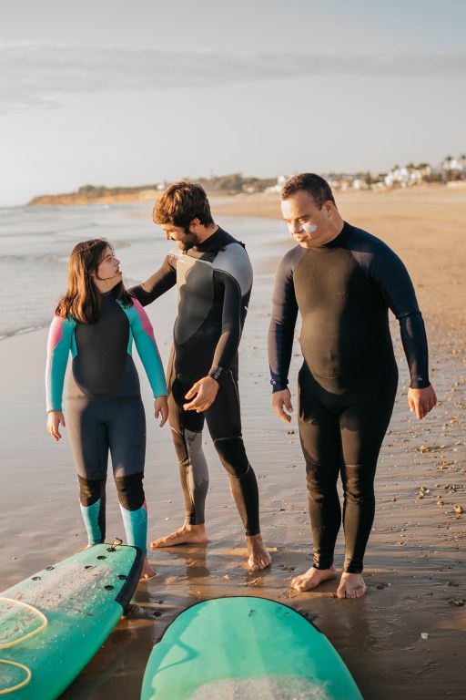 Three people participating in a Therapeutic Surfing lesson in La Barrosa, Spain