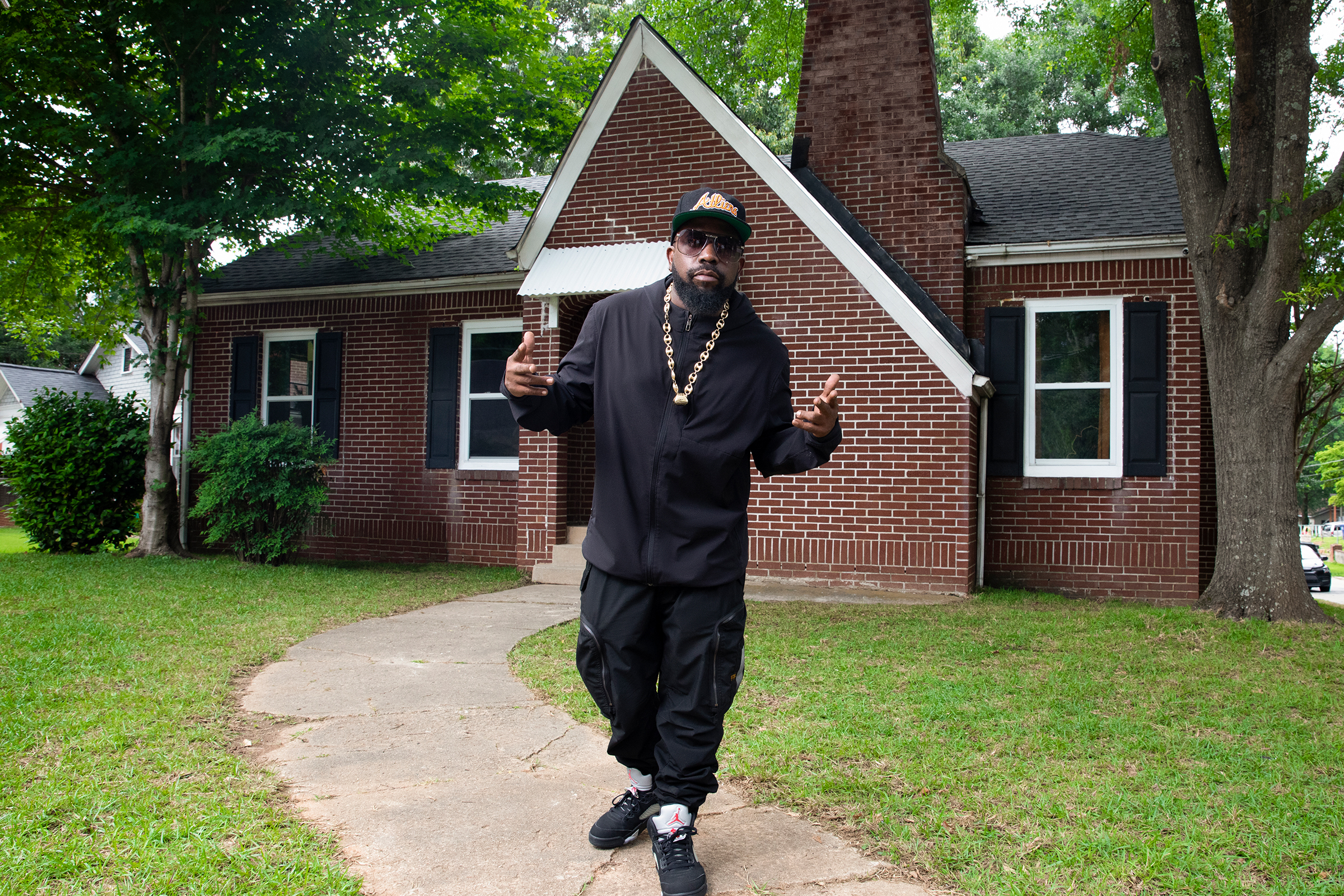 Big Boi standing in front of the Dungeon House exterior welcoming potential future guests