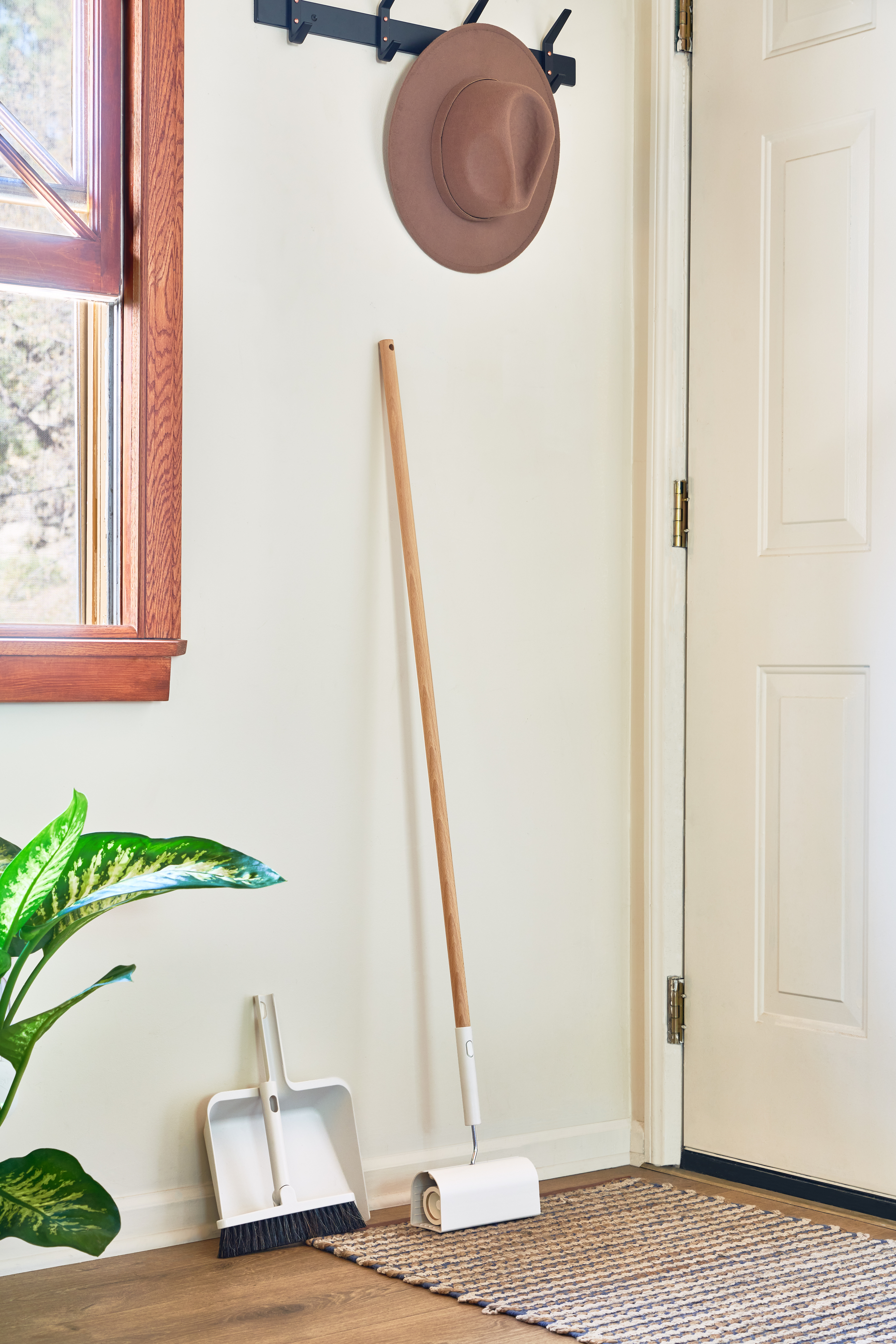 Entryway of an Airbnb with a broom and duster featured in the Host start kit.