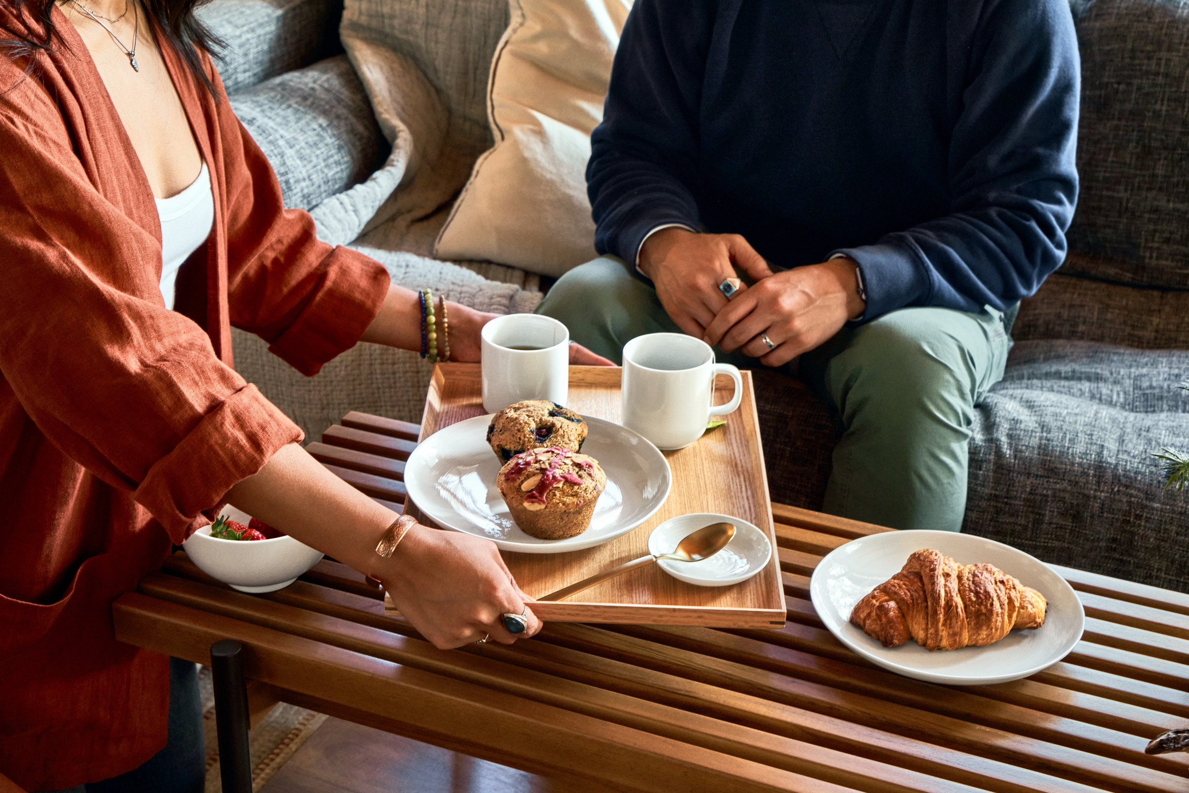 Female guest lower tray of muffins with mugs and plates featured in the essential kit.