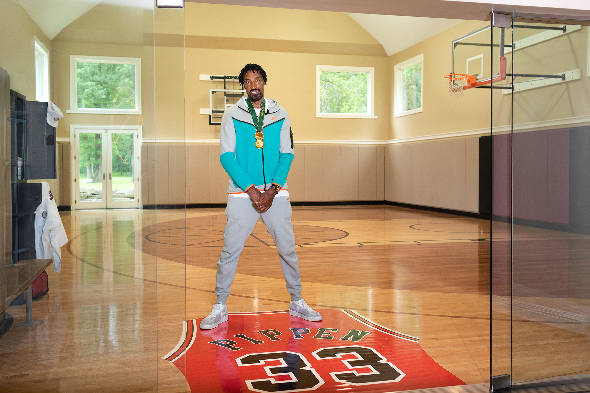 Scottie Pippen stands at the entrance of his indoor basketball court which has a custom #33 jersey printed on the floor.