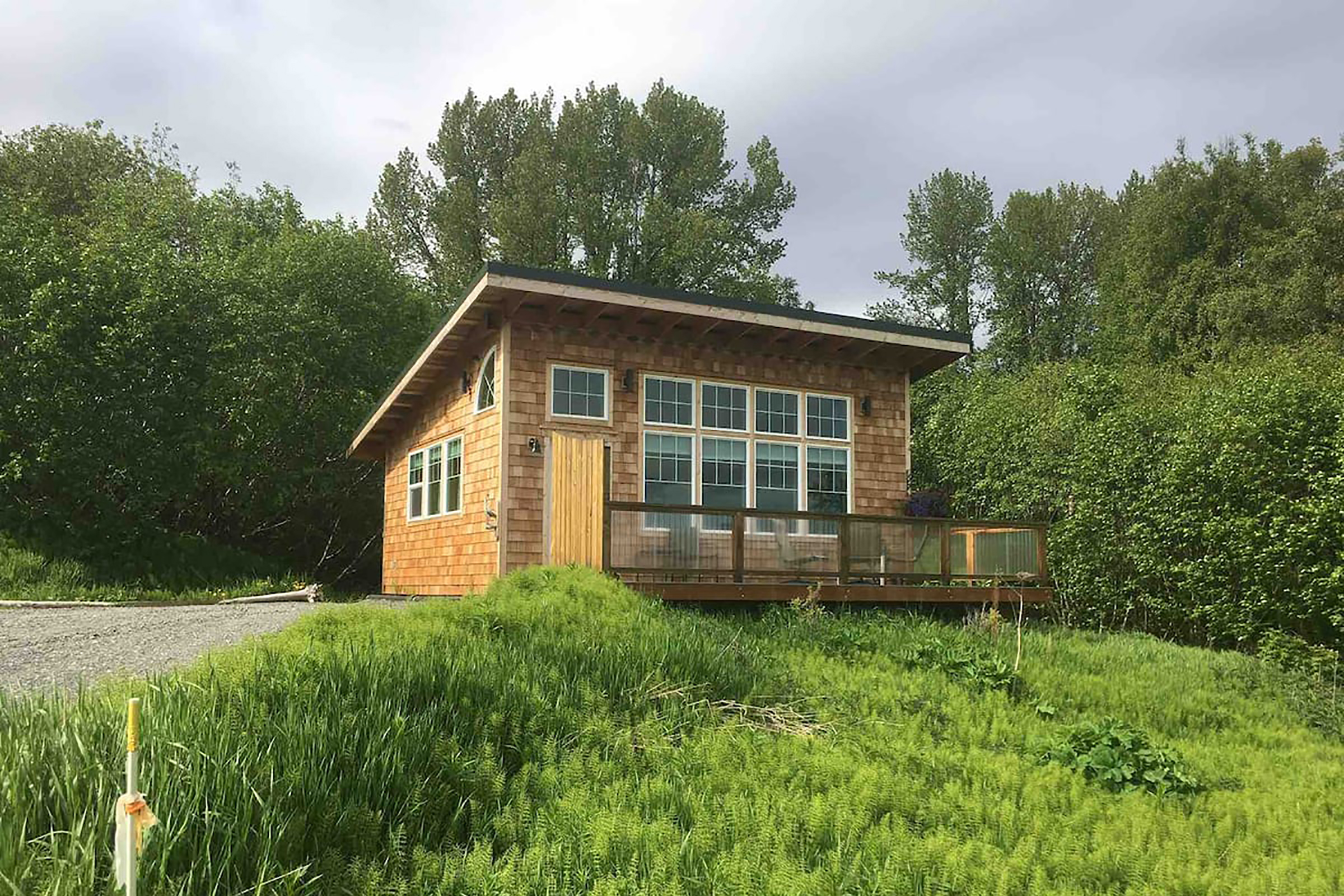 A brown, shingle tiny home with a front porch.