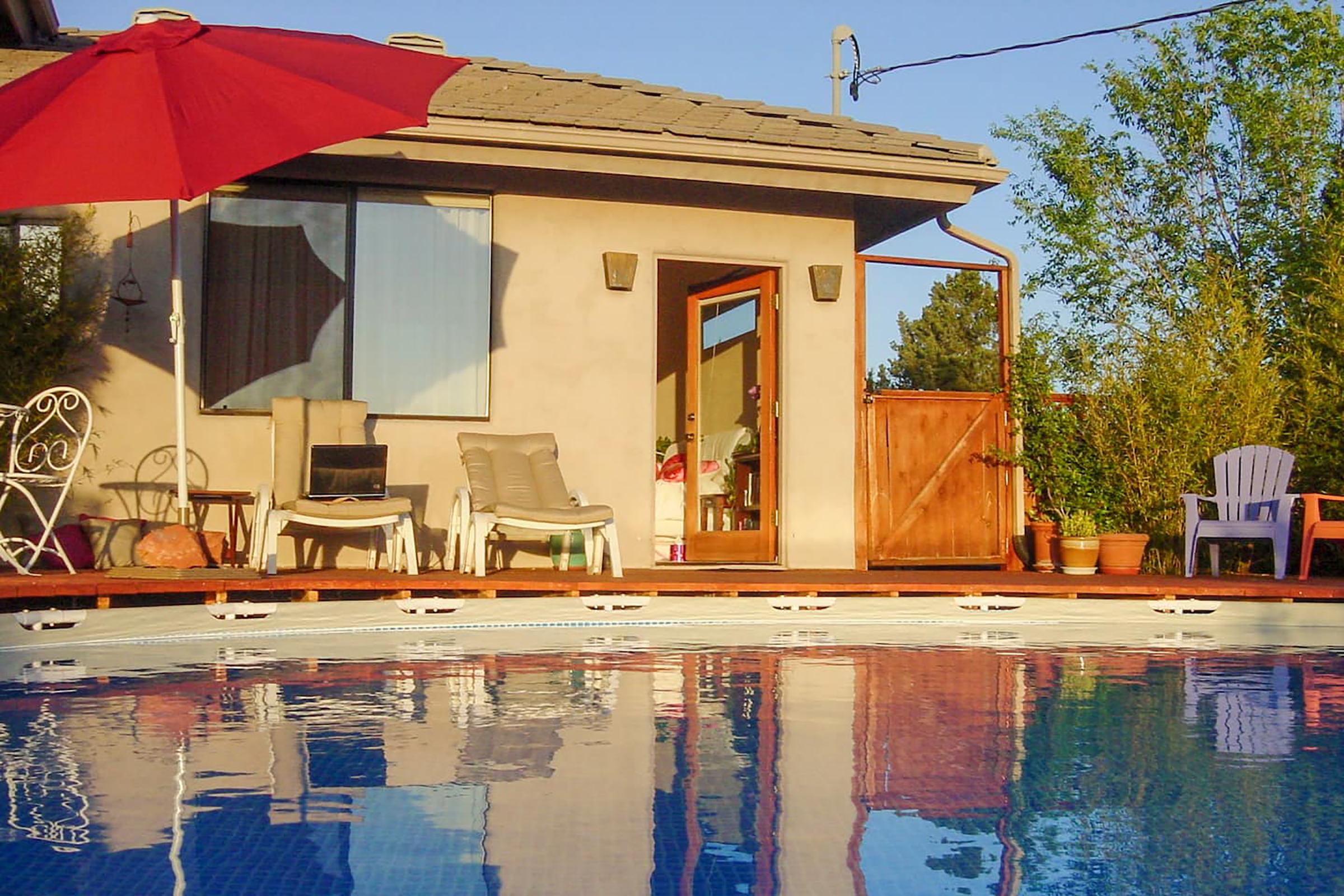 Lounge chairs set in front of a pool with blue water
