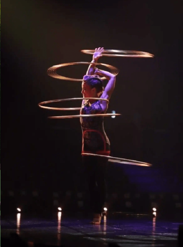 Woman performing using five hula hoops at once