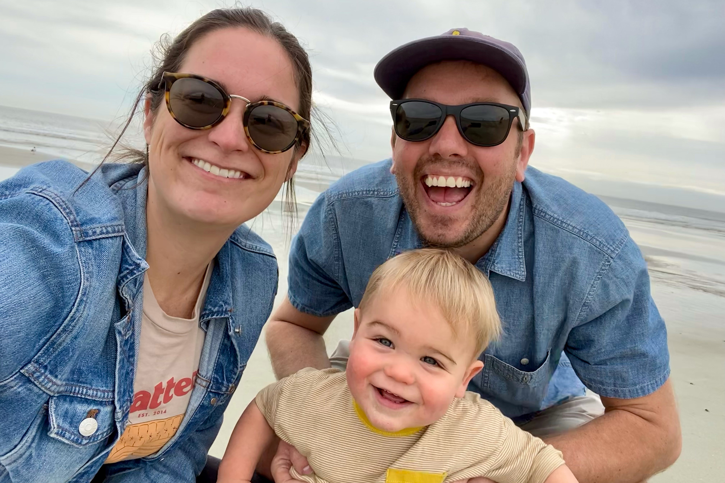 Stephanie, her husband and her son taking a selfie on the beach.