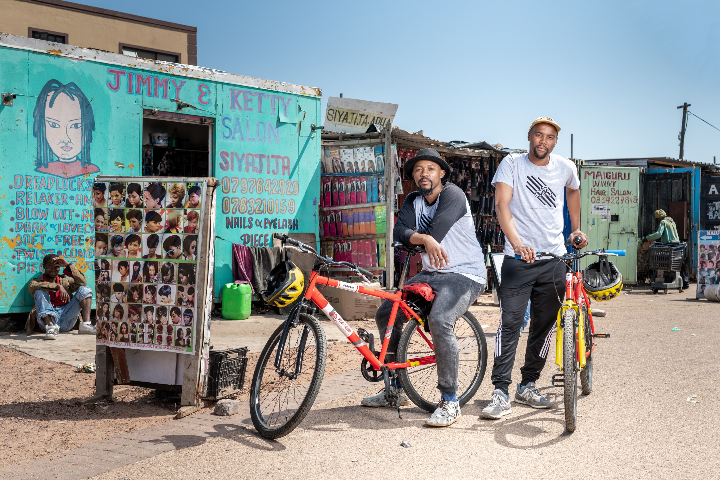 Two men pose next to their bikes in South Africa.