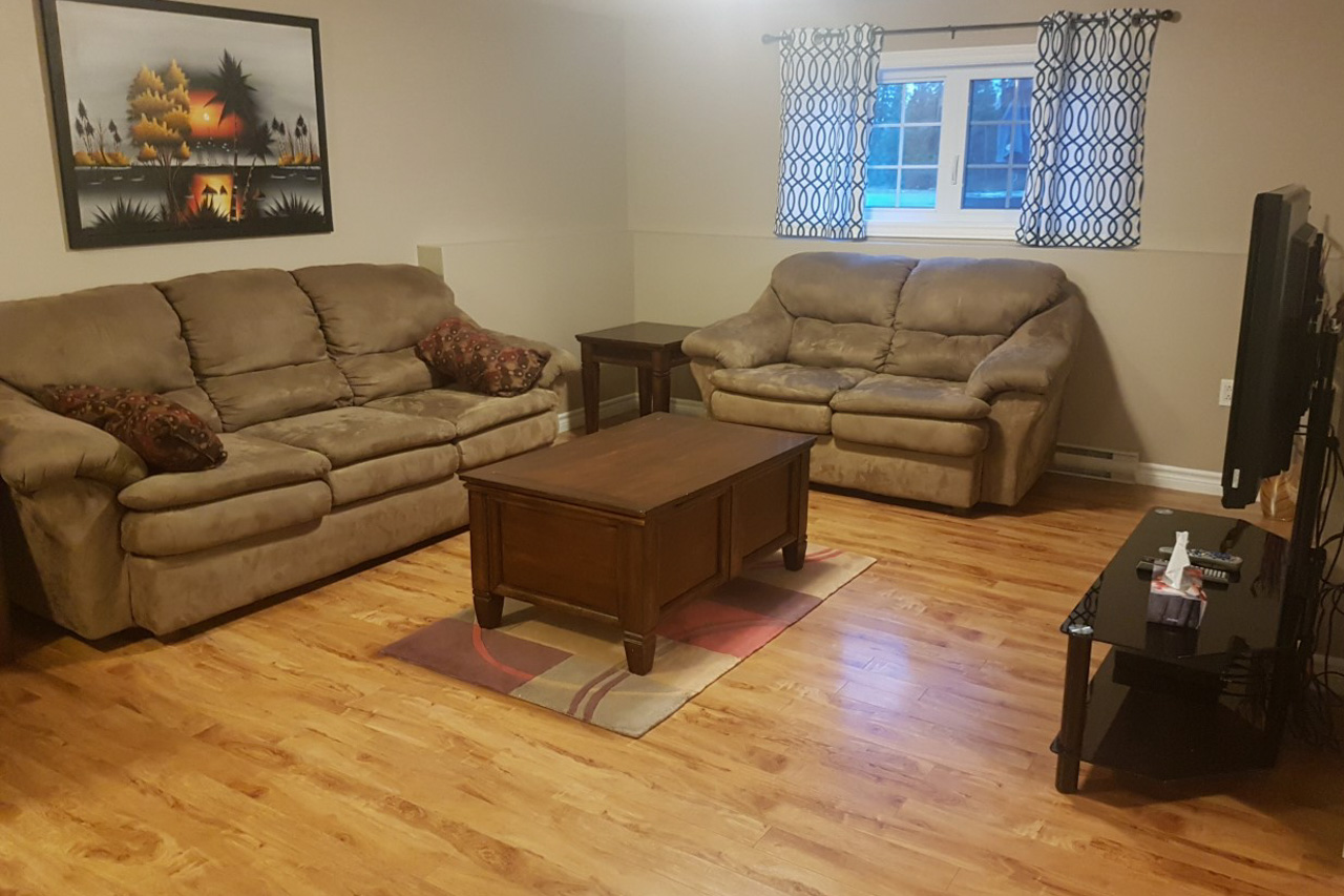 Living room with tan colored couches and a brown wooden coffee table