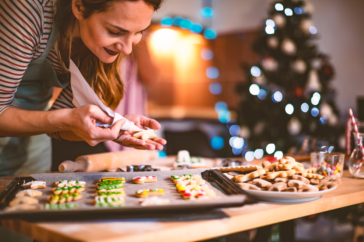 Young woman decorating a Gingerbread cookies for Christmas
