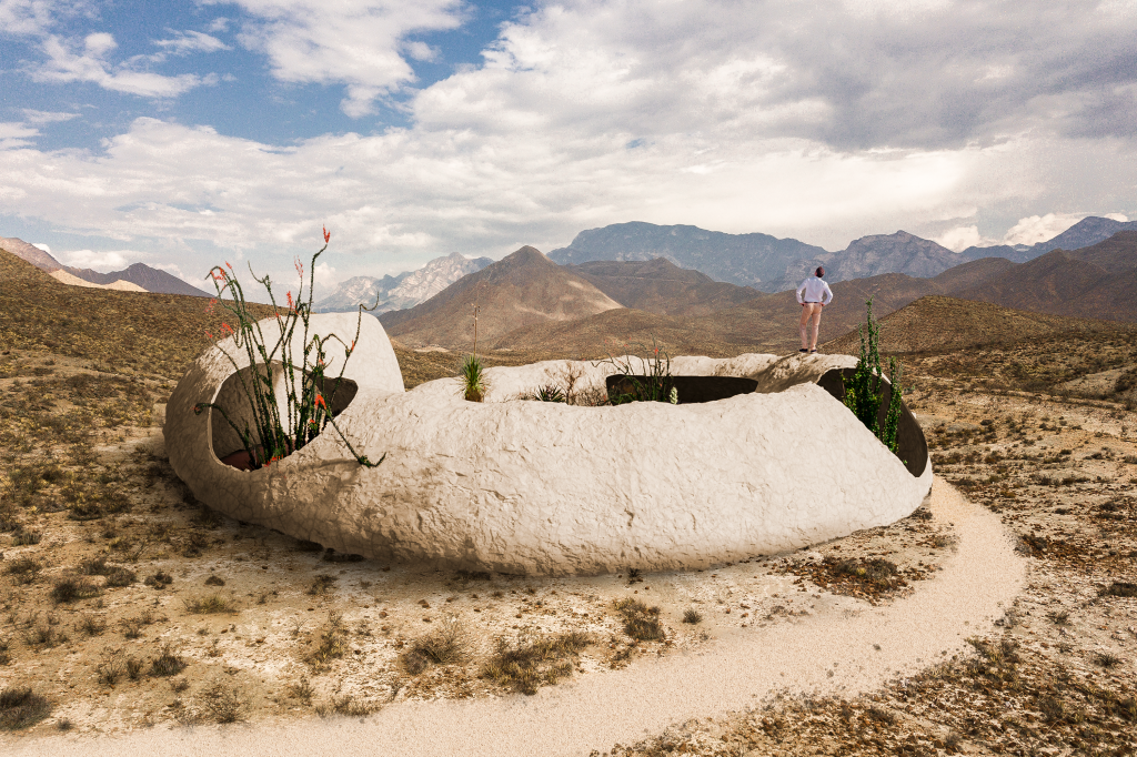 A desert home shaped like a fossilized snail with an open ceiling