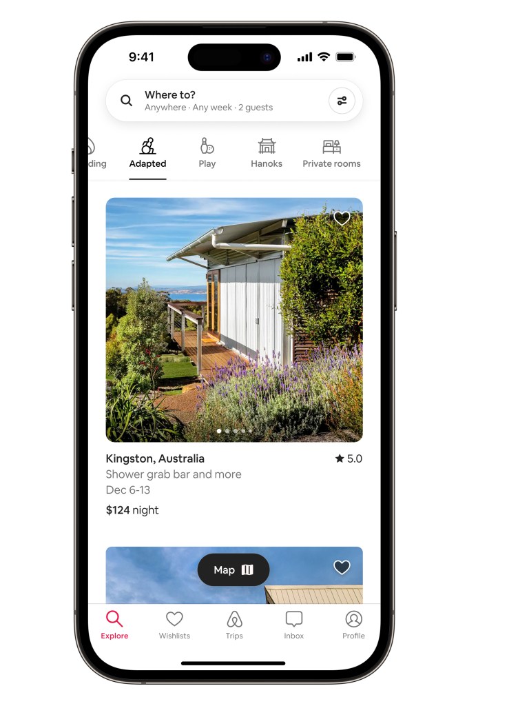 Airbnb Categories product in situ within an iPhone device showing the Adapted Category. The screen shows a one-story house in Kingston, Australia with a step-free entrance and vegetation surrounding it. A water view is in the backdrop.