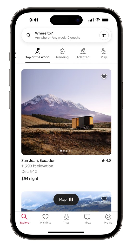 Airbnb Categories product in situ within an iPhone device showing the Top of the World Category. The screen shows a shipping container stay in a prairie with a mountain peak in the backdrop at dusk.