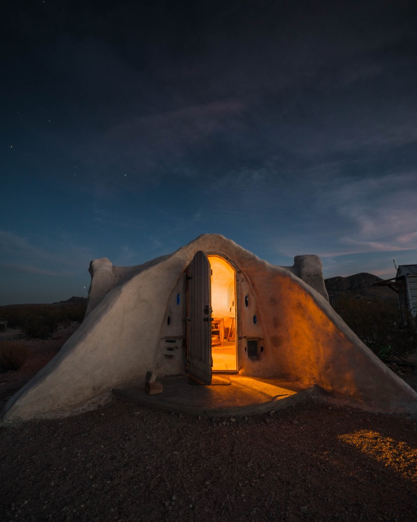 A stone, gray dome-shaped hut with well-lit interior space