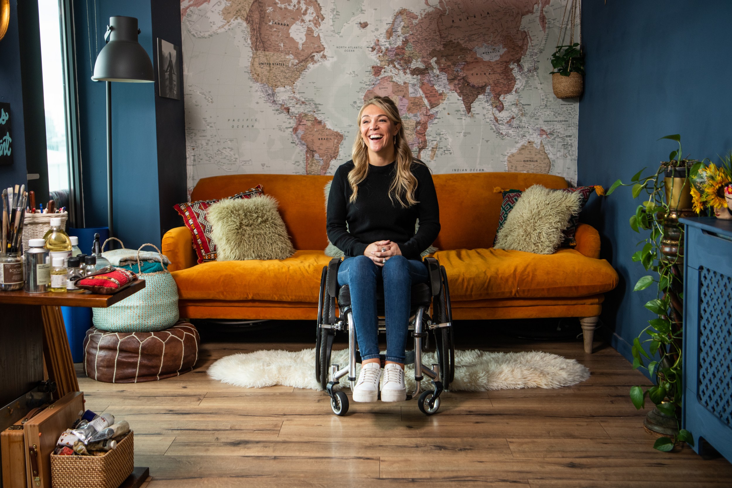 Sophie Morgan sits in the living room of the home she is listing on Airbnb's Adapted Category. Her London listing has been custom-adapted with accessibility features that make it suitable for wheelchair use.