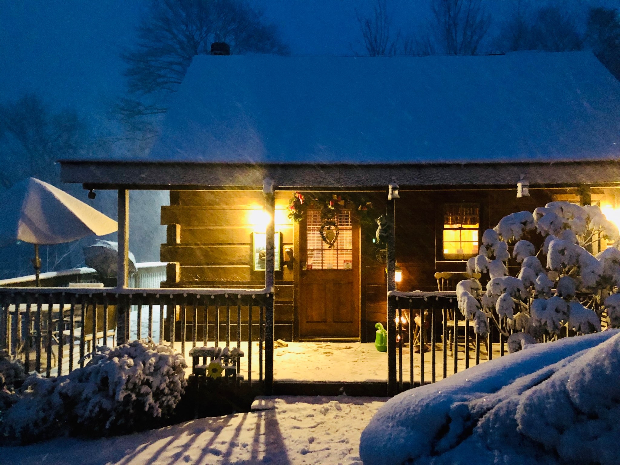 Snow covered cabin with a porch