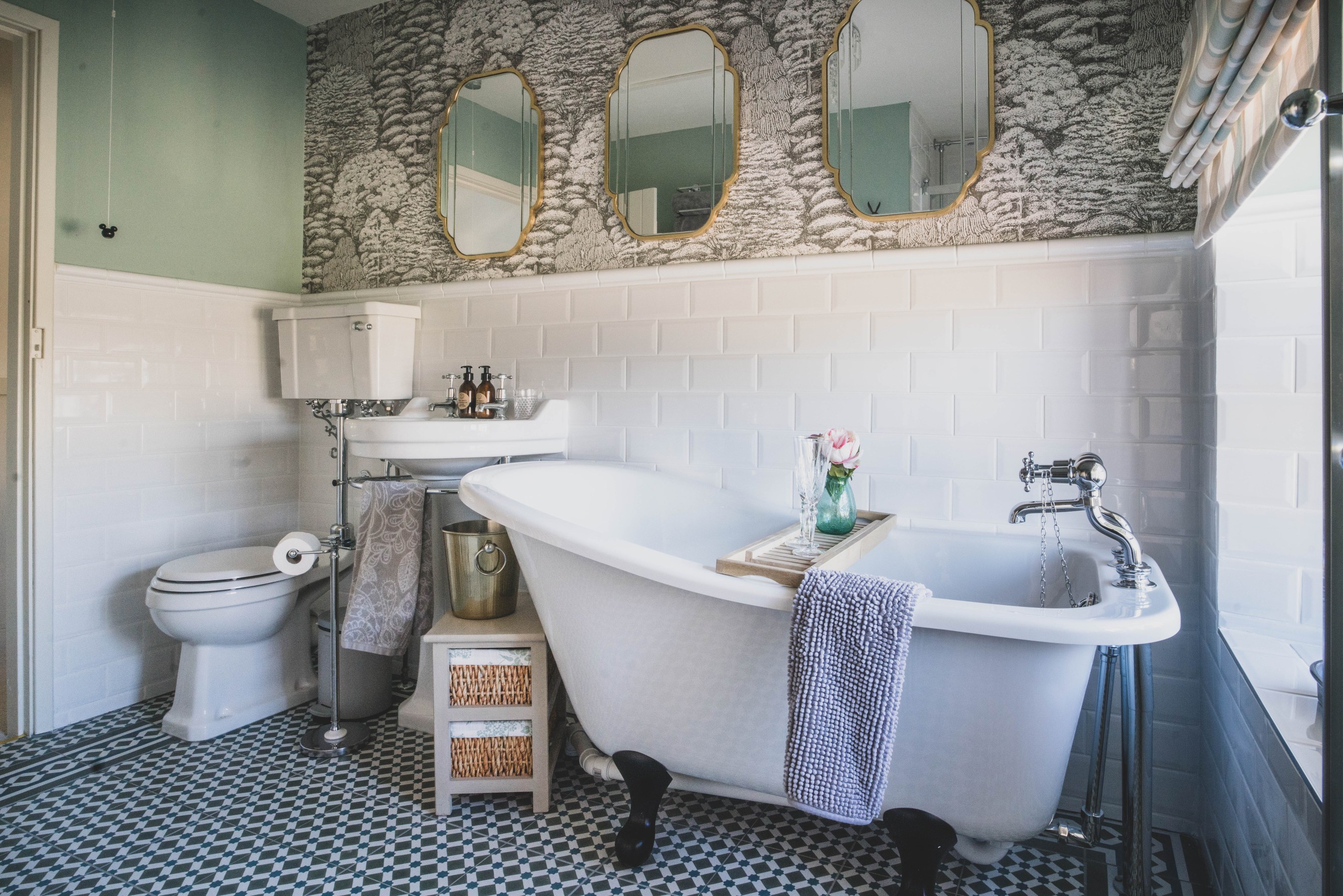 The bathroom has a large bathtub and cottage-like accents which make this a charming room