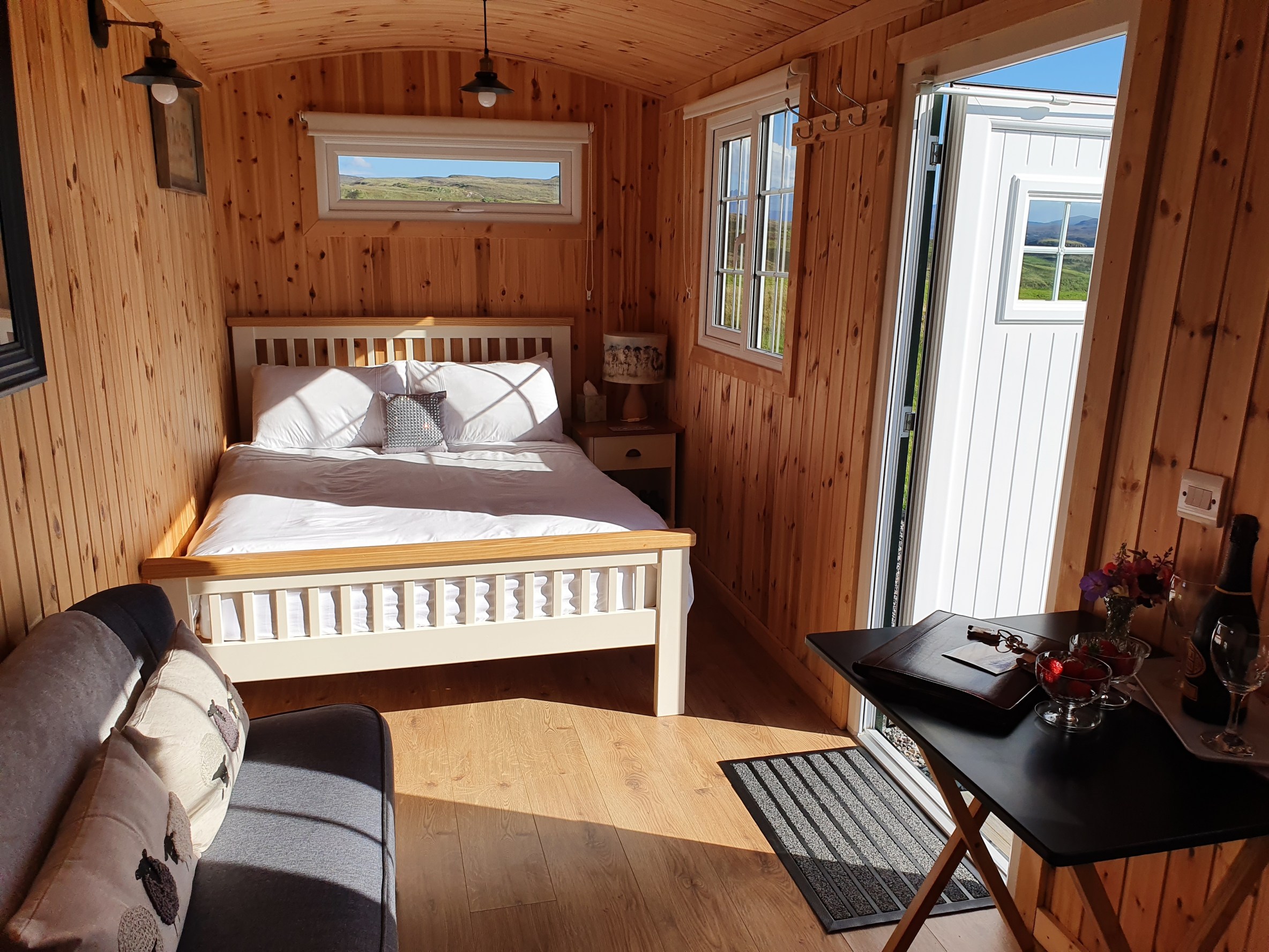 The inside of the caravan, with a double bed and sitting area.