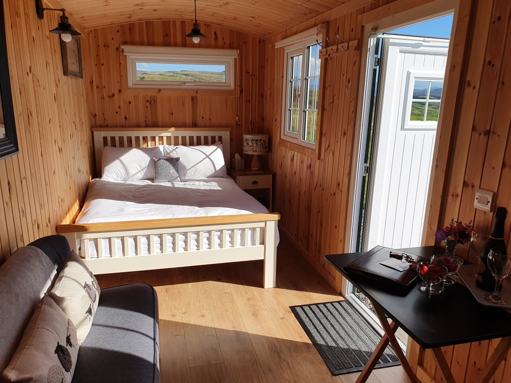 The inside of the caravan, with a double bed and sitting area.