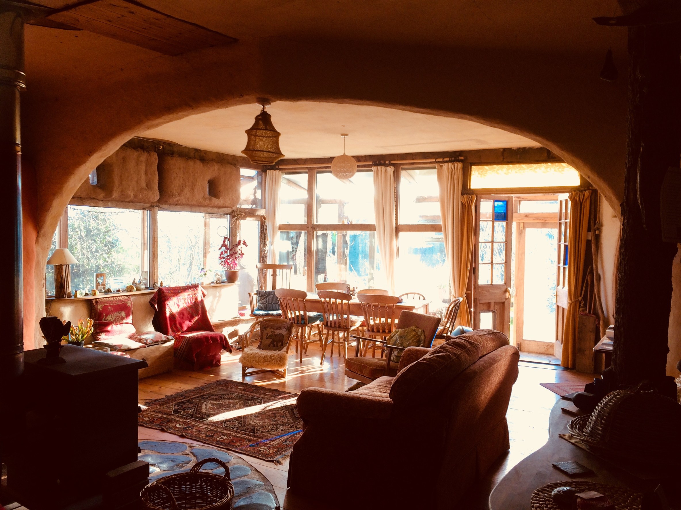 The living room of Rachel's listing is filled with light coming through large windows, looking out to the forrest around. The windows are framed by Comfortable sofas which all face each other - perfect for social gatherings.