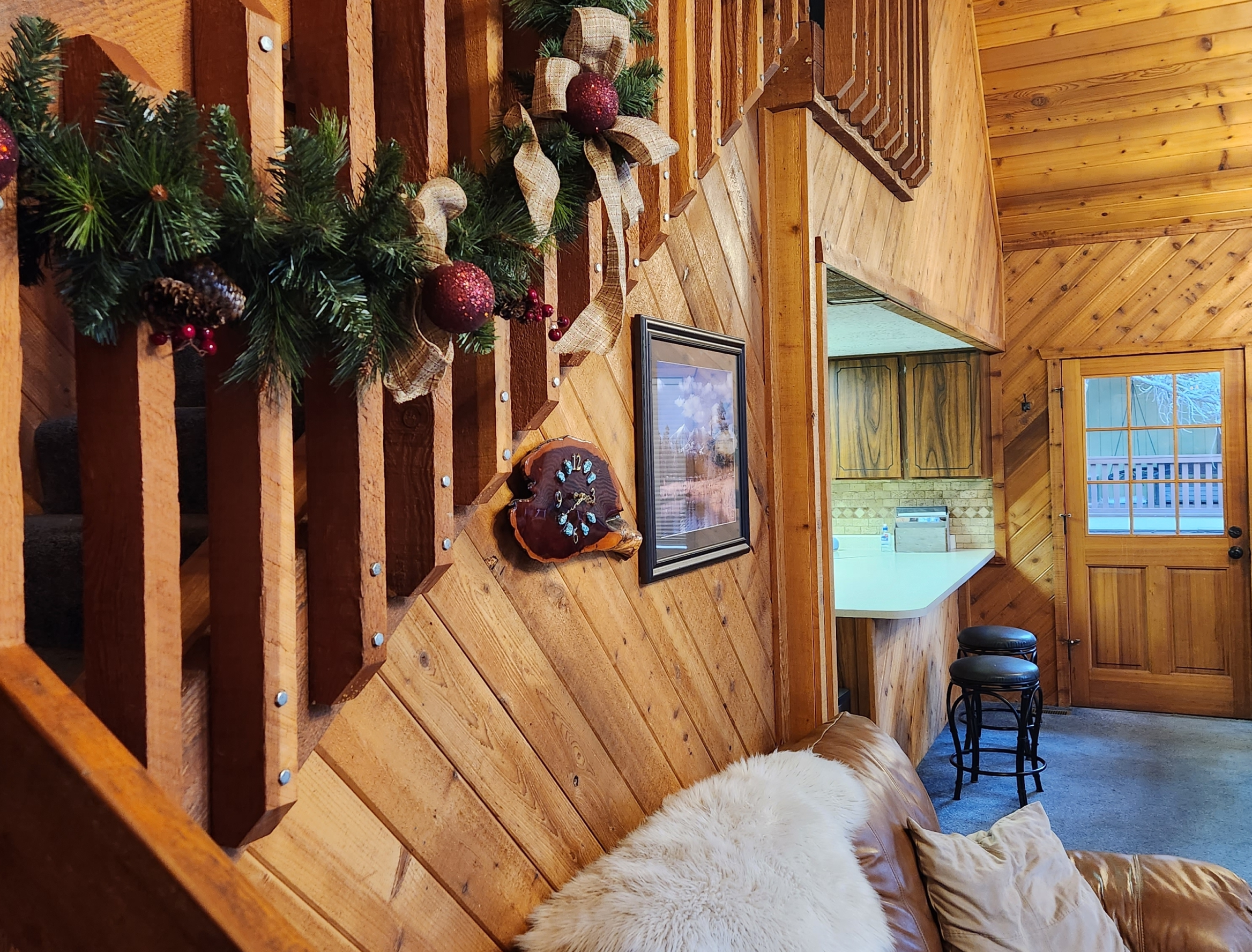 Inside stairway in a cabin home with garland running along the slats of the staircase