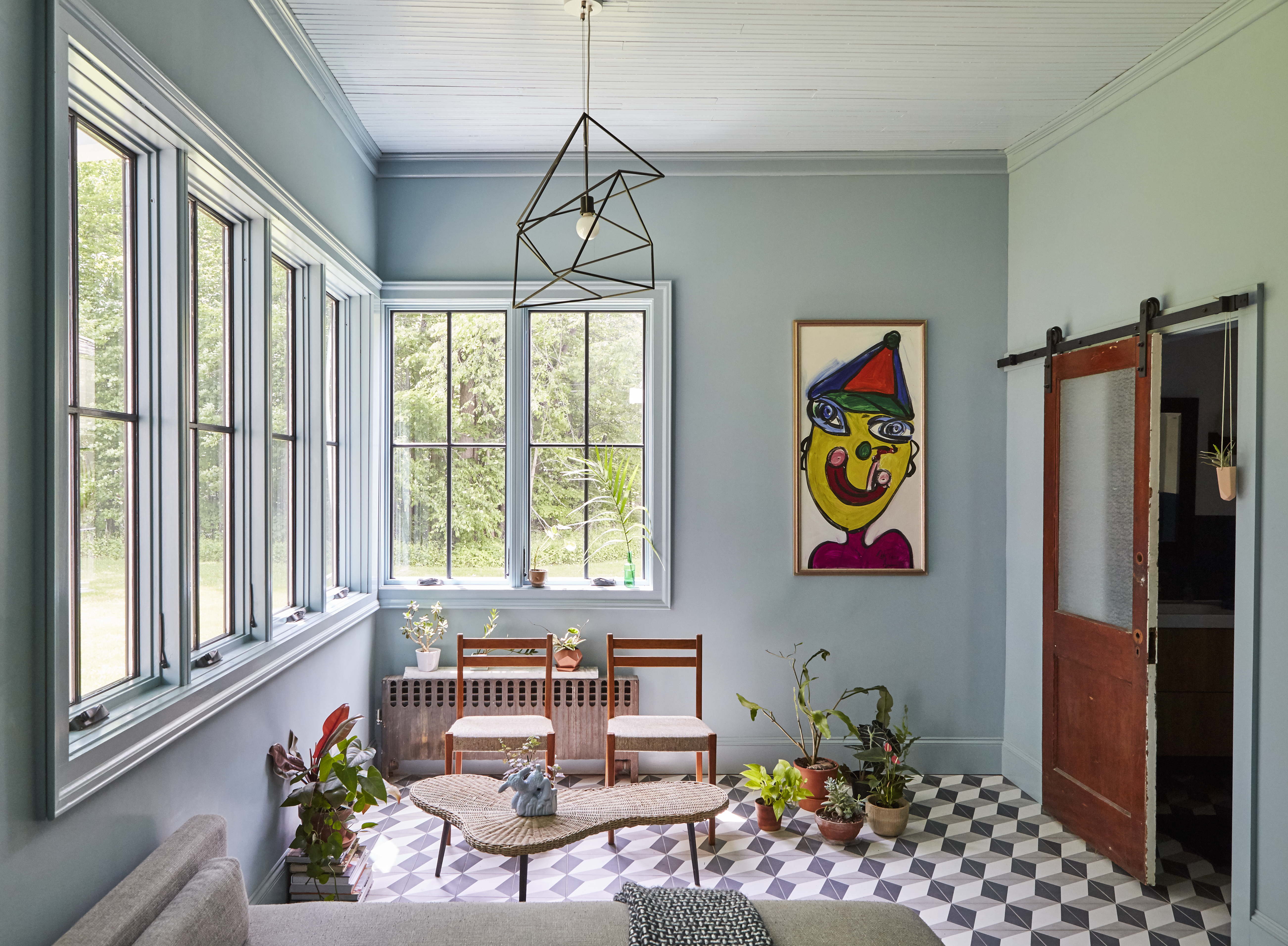 A light blue sun room and playroom area with windows looking out onto the yard.