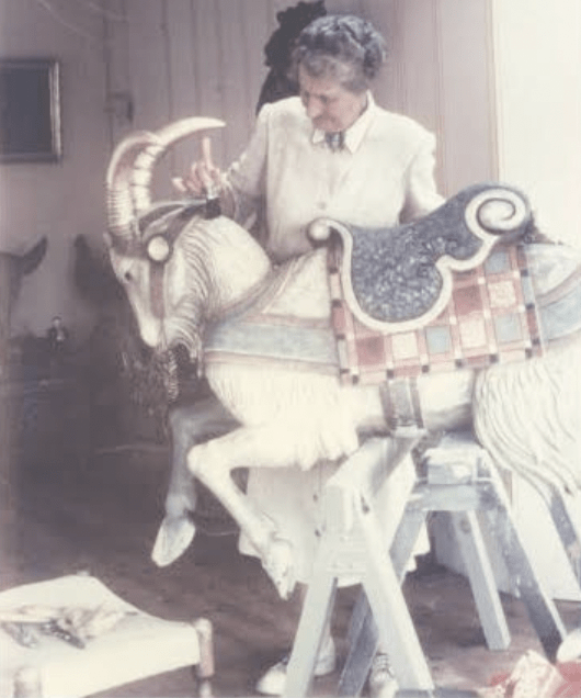 Historical photo of the former owner of The Pond House, Reginald Marsh, painting a life-sized wild goat figurine.