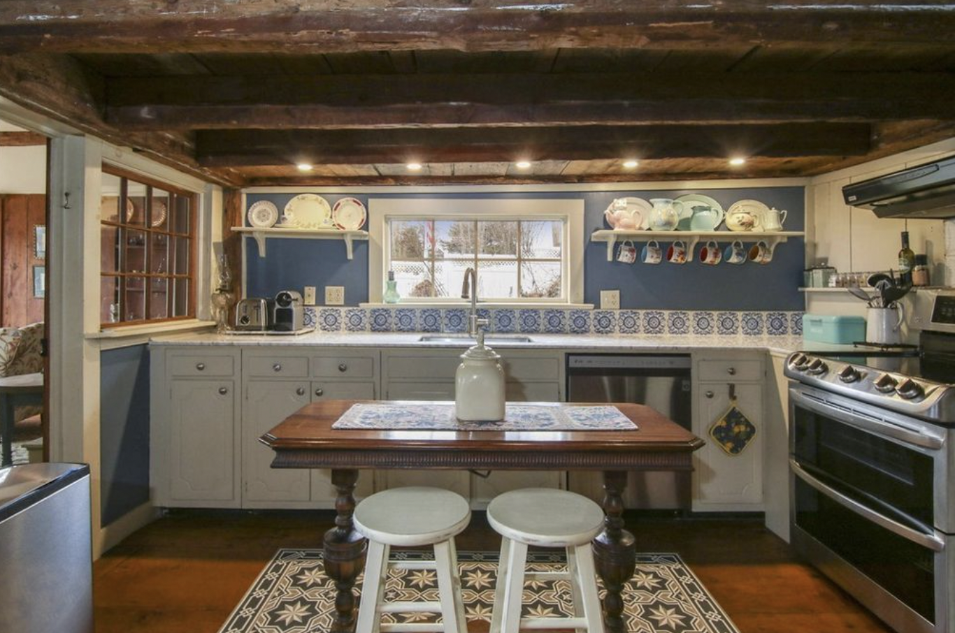 Quintessential Waterfront home kitchen before renovation -- low ceilings with exposed wooden beams, old farmers kitchen style.