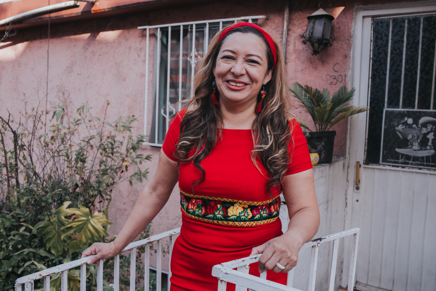 Mine Jiménez, anfitriona mexicana vestida de rojo, sonriente en la puerta del espacio que tiene en la plataforma
