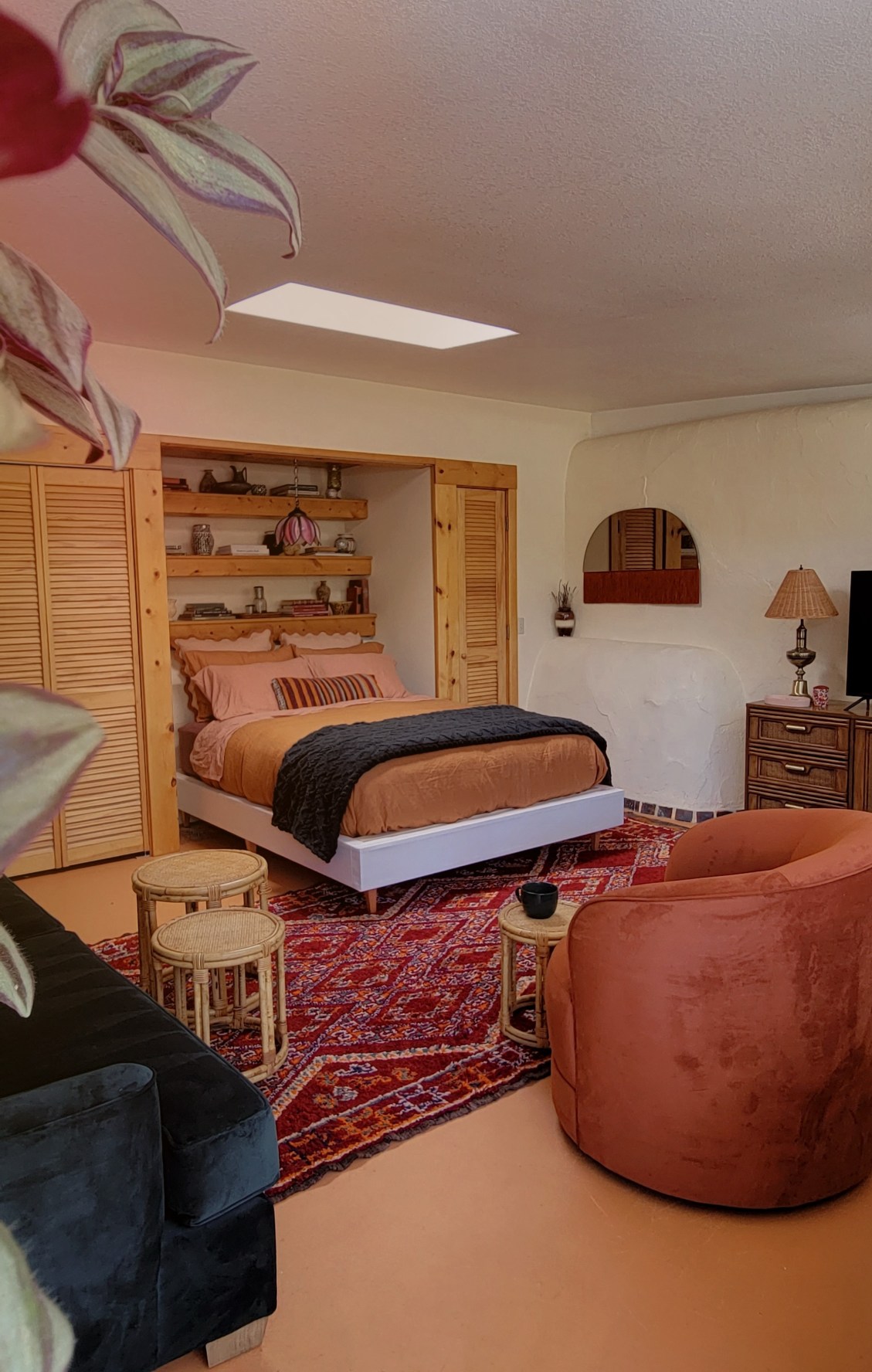 bedroom furnished with a bed, small seat, table and sofa in the Earthen Home in the Forest