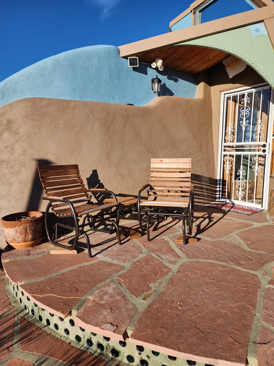 Two chairs on the front patio of the Peaceful Earthship Oasis