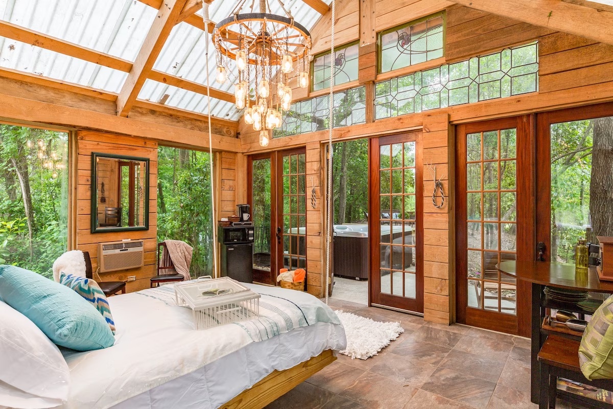 Timber A-Frame cabin with a double bed and chandelier. 