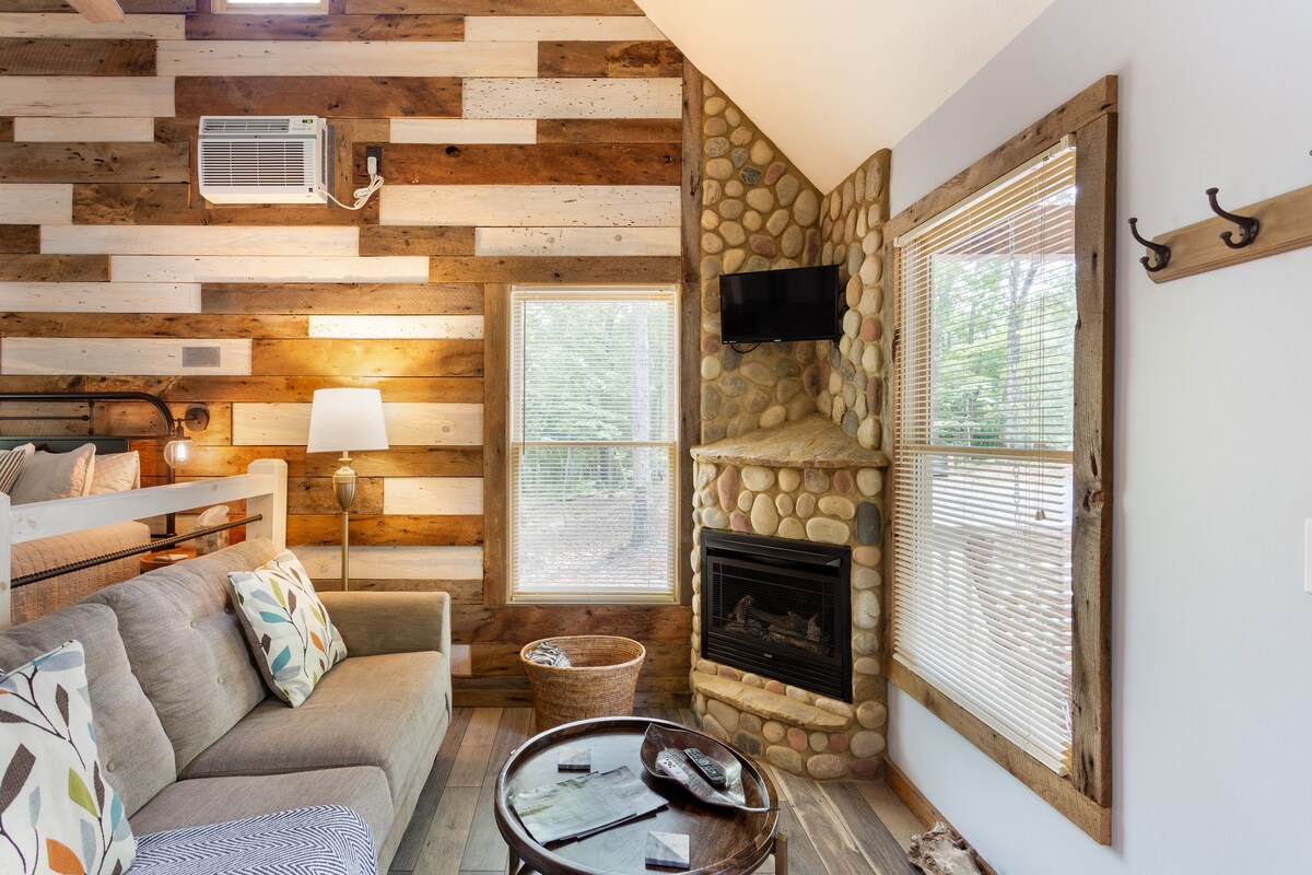 Picture of a sofa, campfire and TV in a cabin. 