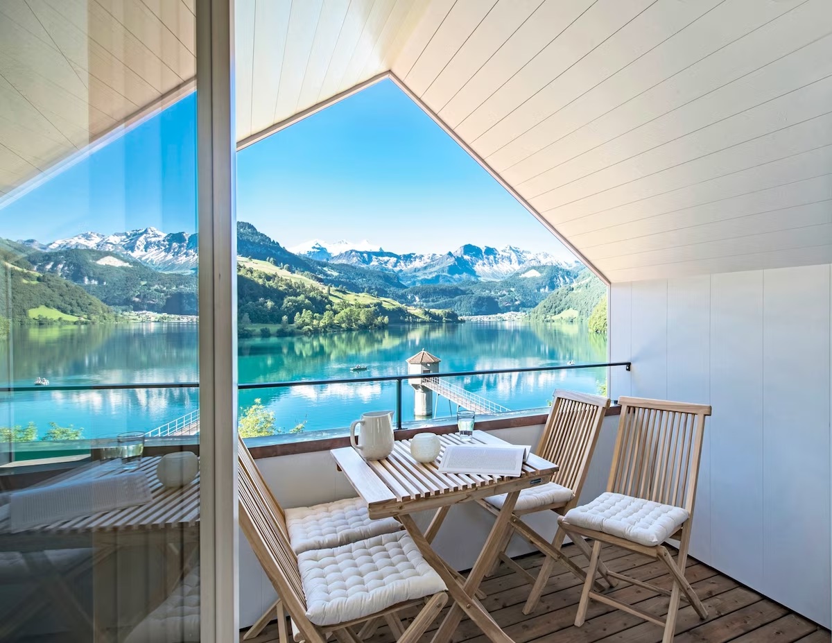 Small dining table set overlooking turquoise waters and a mountain vista