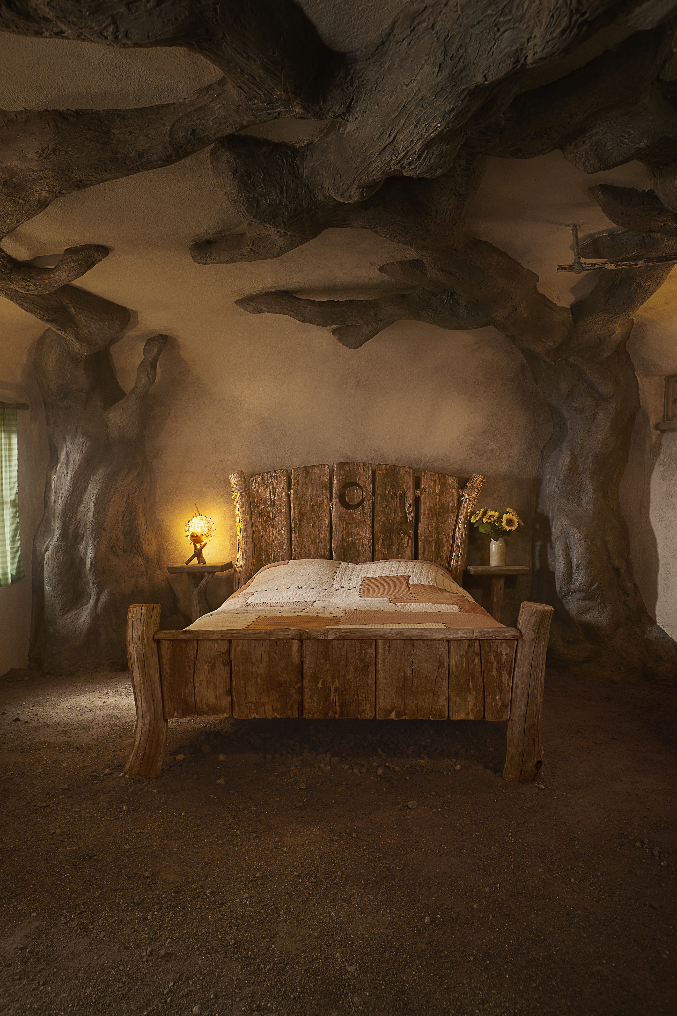 Bedroom in Shrek's Swamp, a wooden bed with small bedside tables on either side