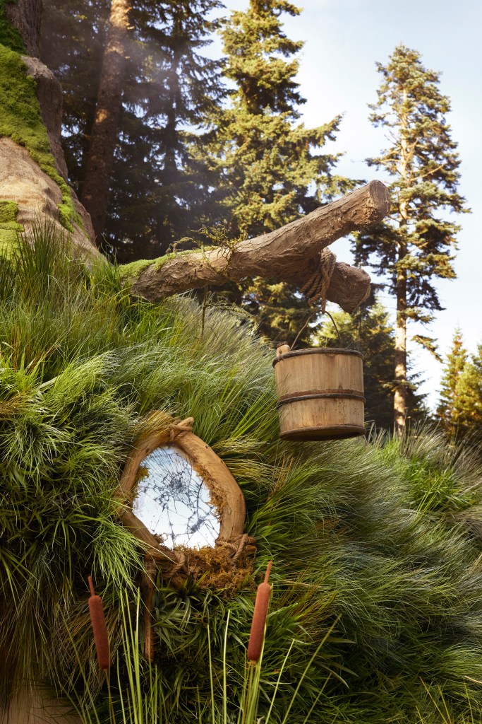 Exterior of Shrek's Swamp - a wooden bucket hangs from a tree branch outside the house