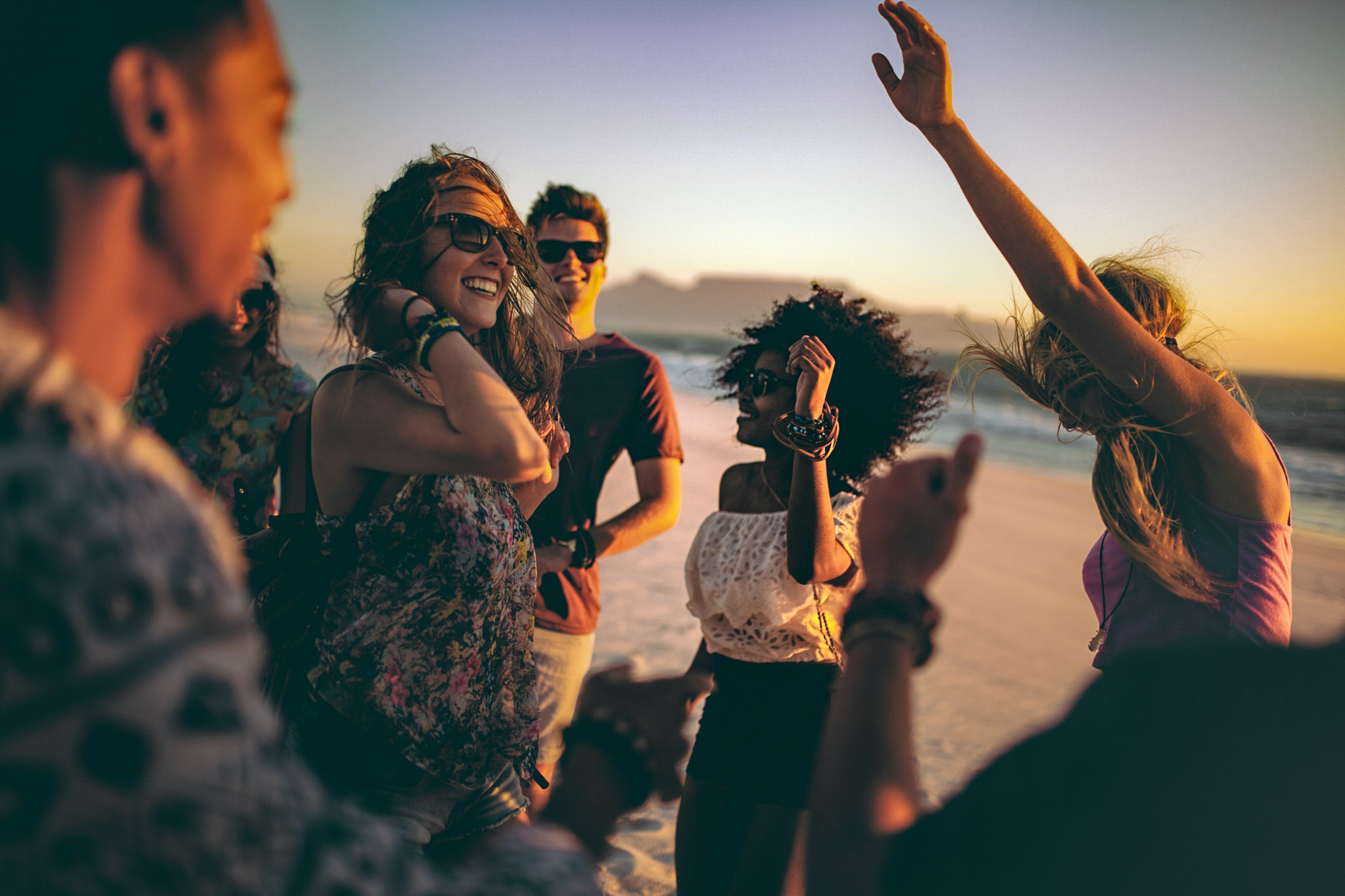Grupo de amigos bailando en la playa