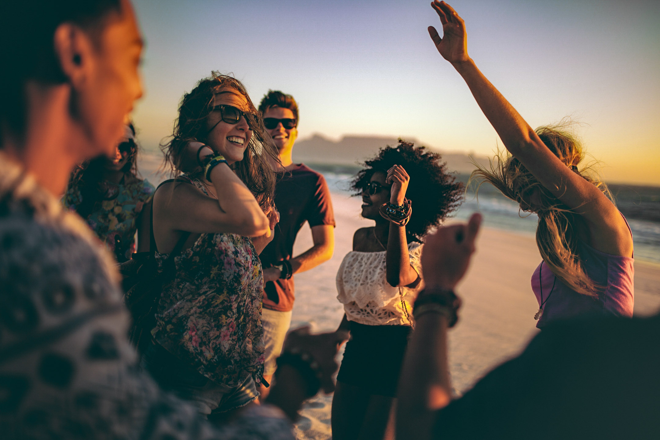 Friends dancing together during sunset