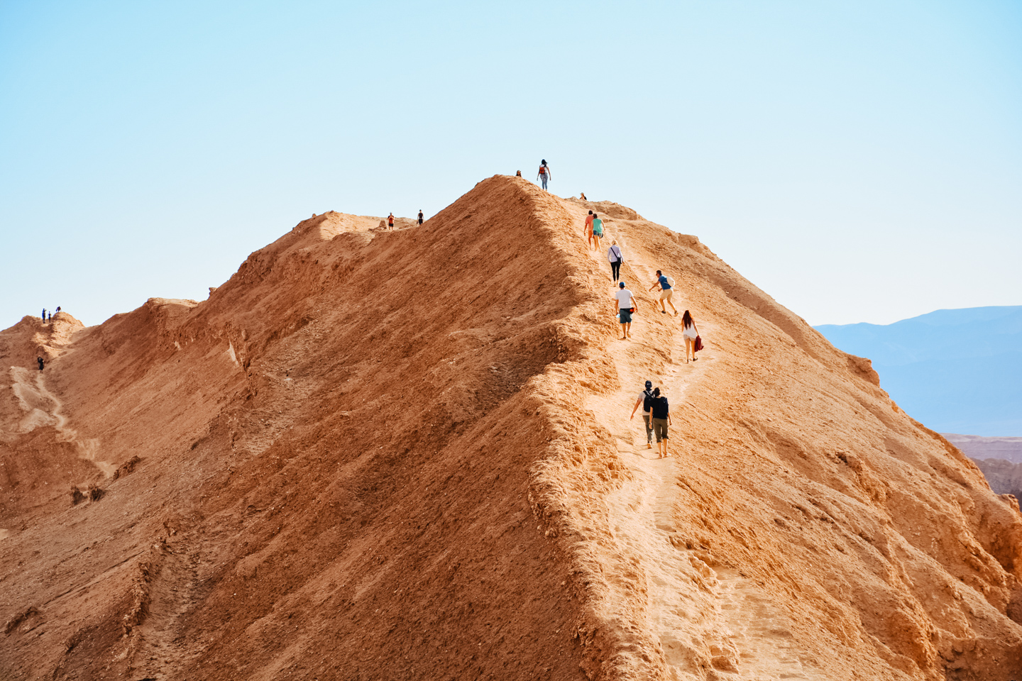 Grupo de personas caminando en la cima de una montaña en el desierto de Chile